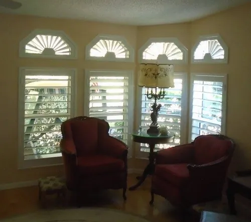 Custom shutters fitted to fan-top and specialty-shaped windows in a Nocatee home