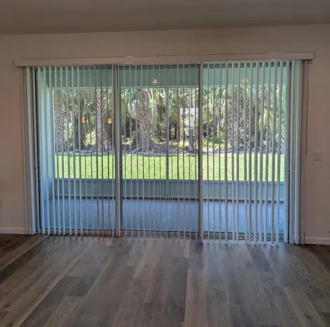 Custom vertical blinds covering a wide sliding glass door in a Nocatee home